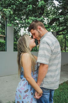 一对年轻夫妇在绿树环绕的户外，分享着温柔的恋爱时光