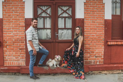 Free White Dog Between Smiling Man and Woman Stock Photo