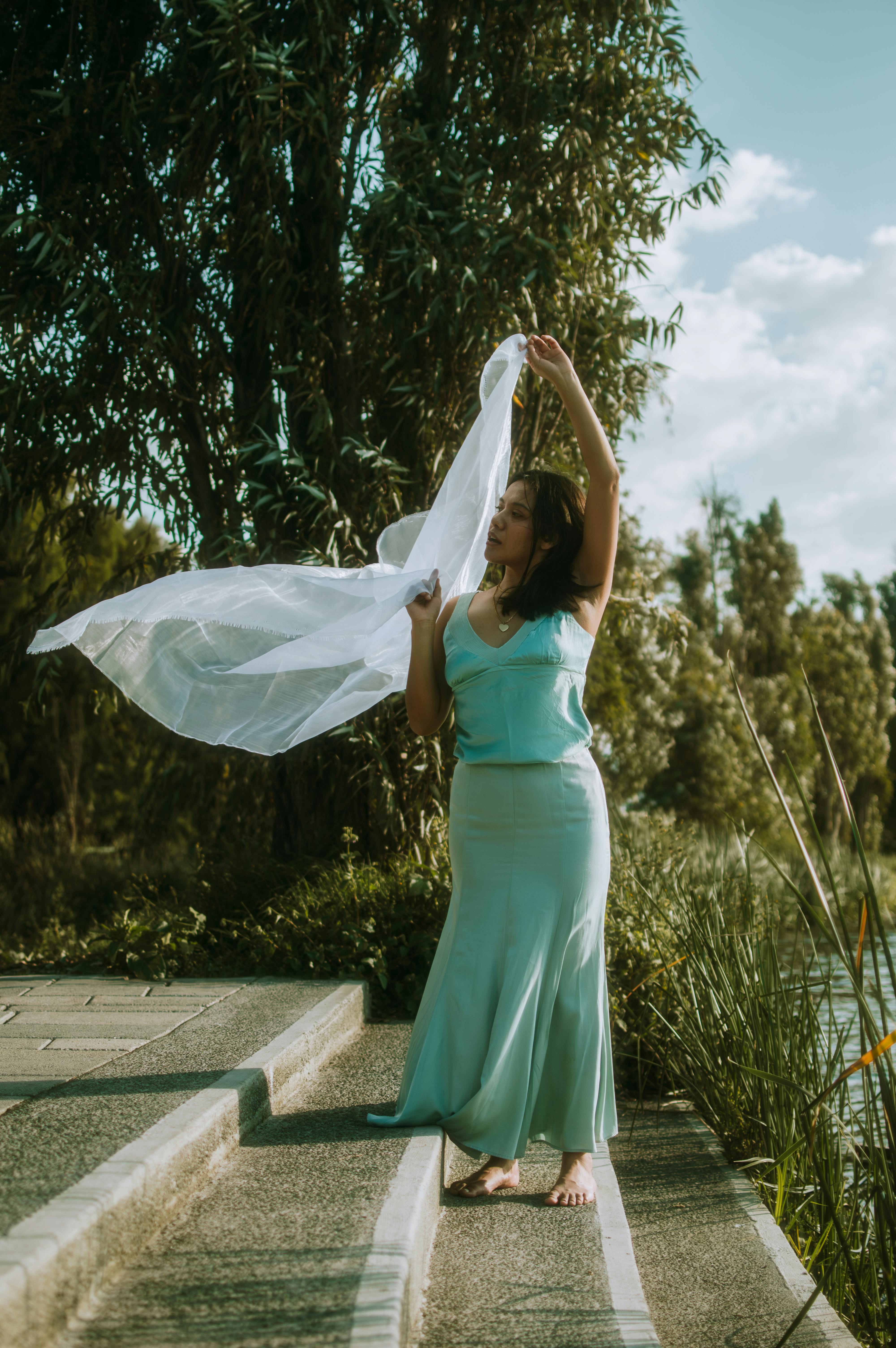 A woman in a mint dress stands on stairs with a veil, set in lush greenery in Mexico City.