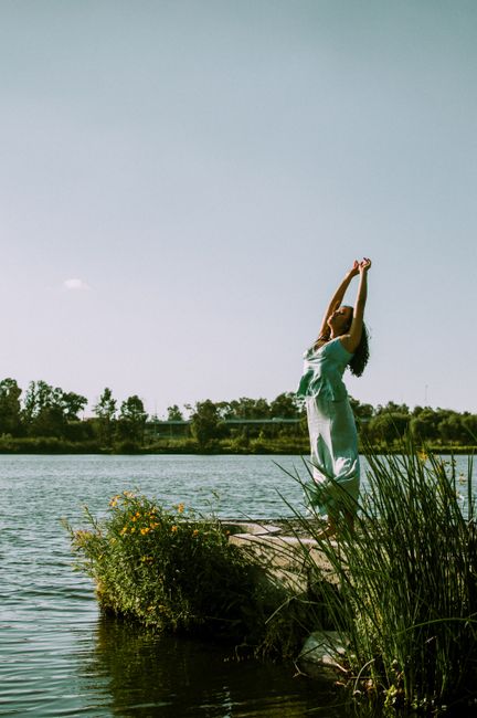 A woman in a dress enjoys a sunny day by the lake, embracing nature's beauty in Ciudad de México.