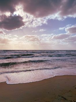 Capture of a serene sunset on a Melbourne beach with clouds and gentle waves.