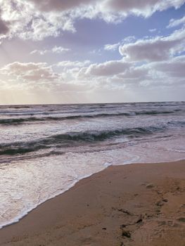 Peaceful beach view at sunset with gentle waves in Melbourne, Australia.
