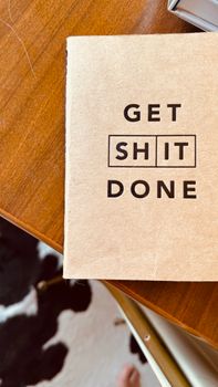 Workspace featuring an inspiring 'Get Shit Done' notebook for increased productivity.
