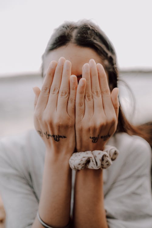 A woman covering her face with her hands