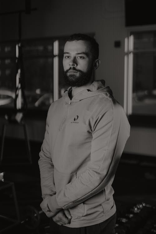 A man with a beard standing in a gym