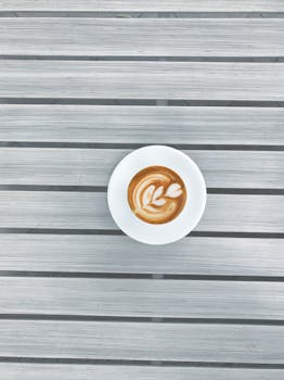光滑的木桌上，拿铁艺术咖啡以鸟瞰视角展示着优雅的极简主义设计
