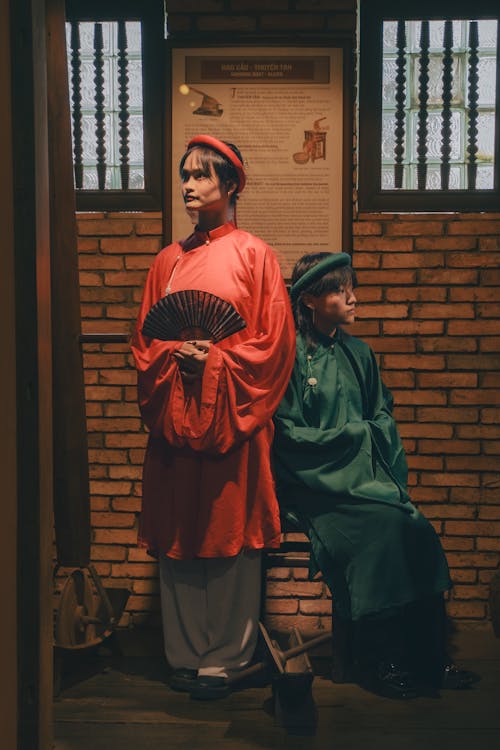 Two people in traditional clothing sitting on a bench