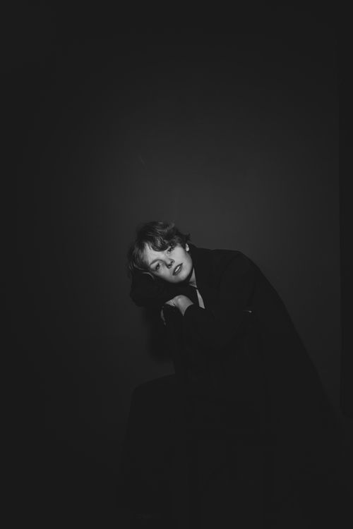 Free A moody black and white portrait of a boy in a studio setting, emphasizing fashion and shadows. Stock Photo