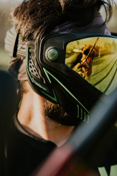 Close-up of a man's head wearing shiny protective goggles with a reflection outdoors.