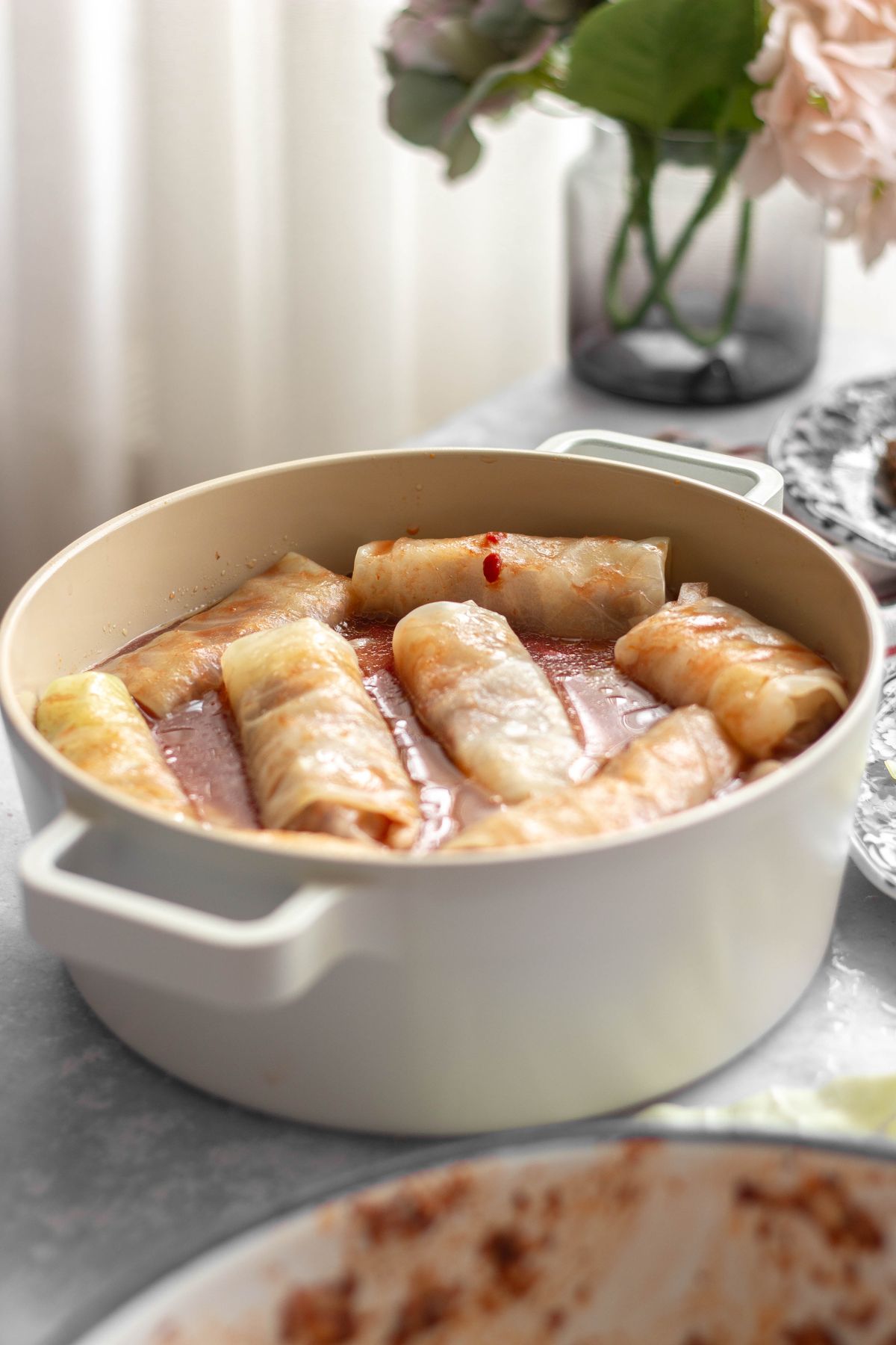 Stuffed cabbage rolls simmering in a rich tomato sauce in a pot