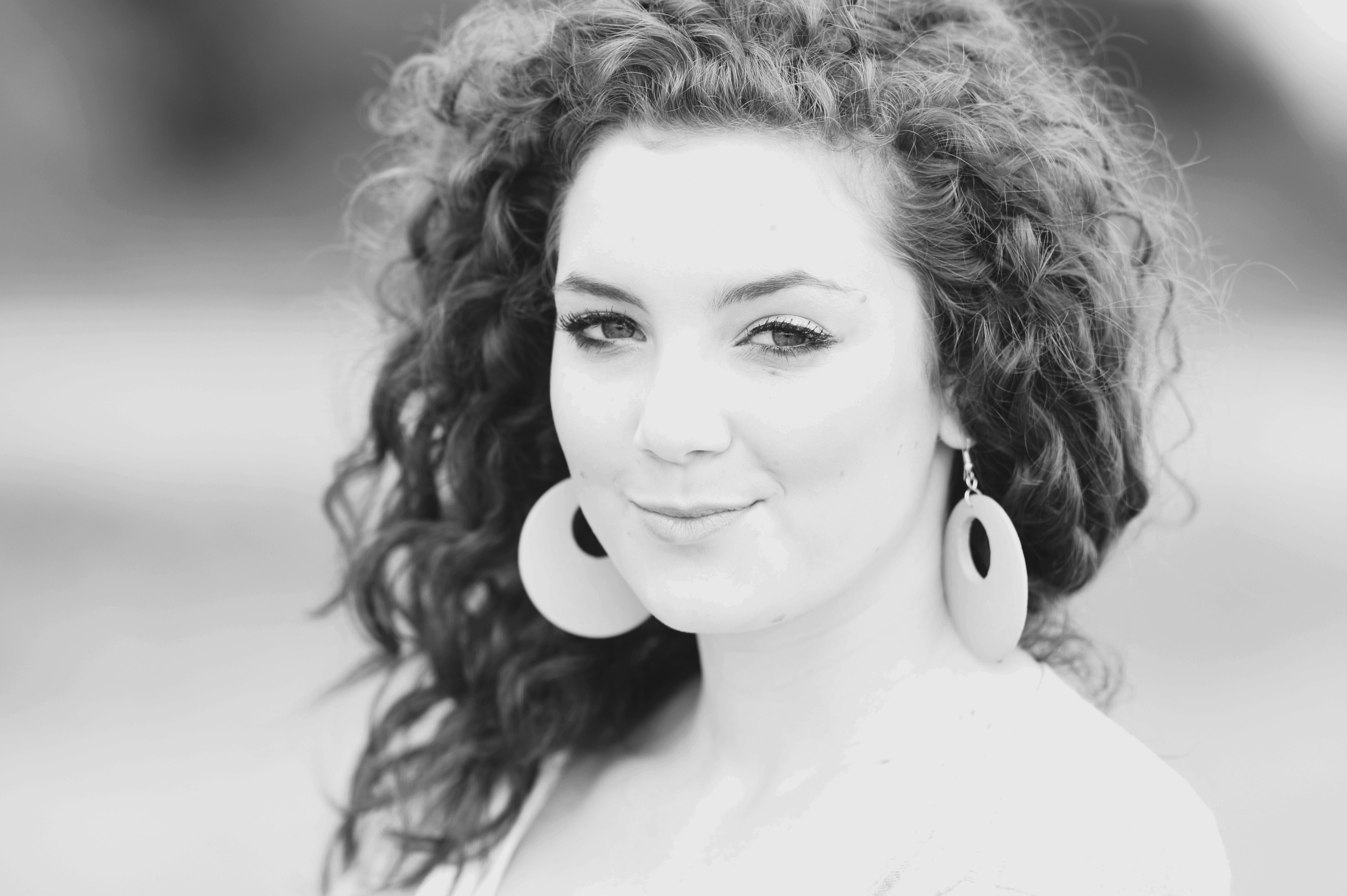A woman with curly hair and earrings · Free Stock Photo
