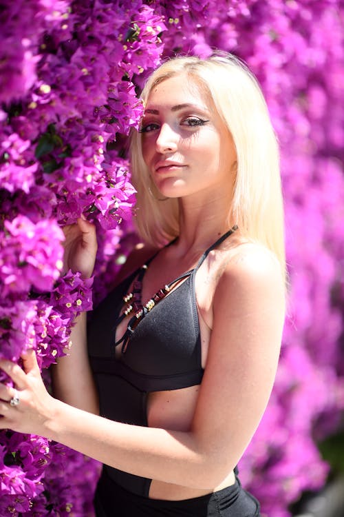 A beautiful blond woman leaning against a purple wall