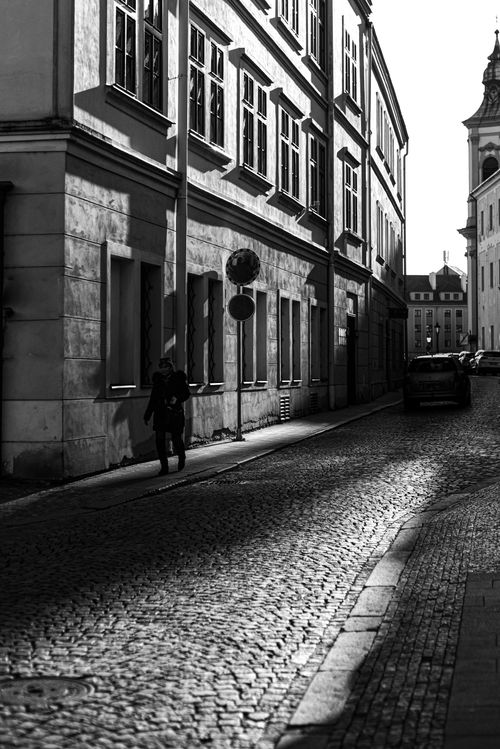 Free Dramatic black and white photo of a historic cobblestone street with urban architecture. Stock Photo