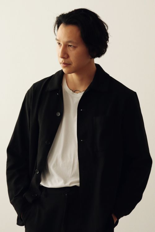 Free Portrait of an Asian man in a black jacket and white t-shirt, studio setting. Stock Photo