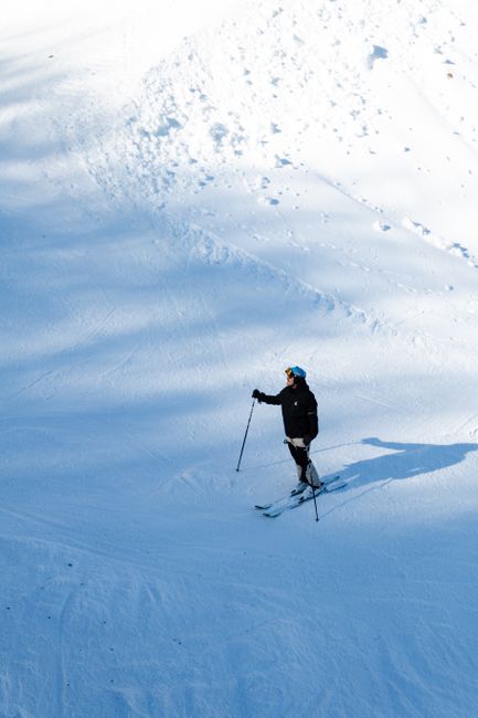 A lone skier enjoying a daytime descent on snowy slopes in Mavrovo, North Macedonia.