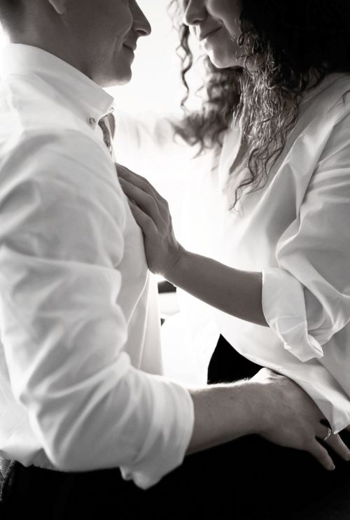 Free A couple sharing an affectionate, intimate moment in a monochrome elegant setting. Stock Photo