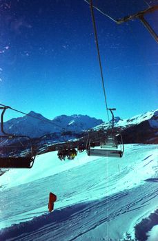 Breathtaking view of snow-covered ski slopes and chairlifts in Sestriere, Italy, under a clear blue sky.