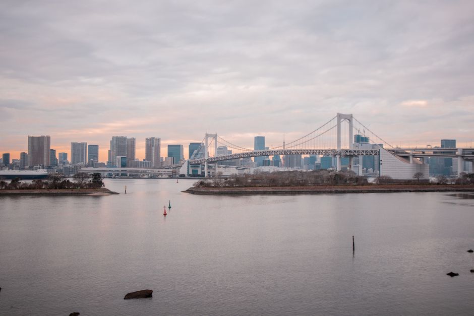 A stunning view of the Yokohama skyline with a bridge at sunset, featuring urban architecture.