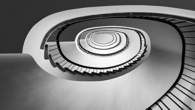 Black and white photo of a spiral staircase showcasing modern architectural design.