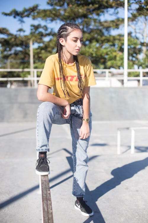 Mulher Com Cabelo Trançado, Camisa Amarela E Jeans No Parque