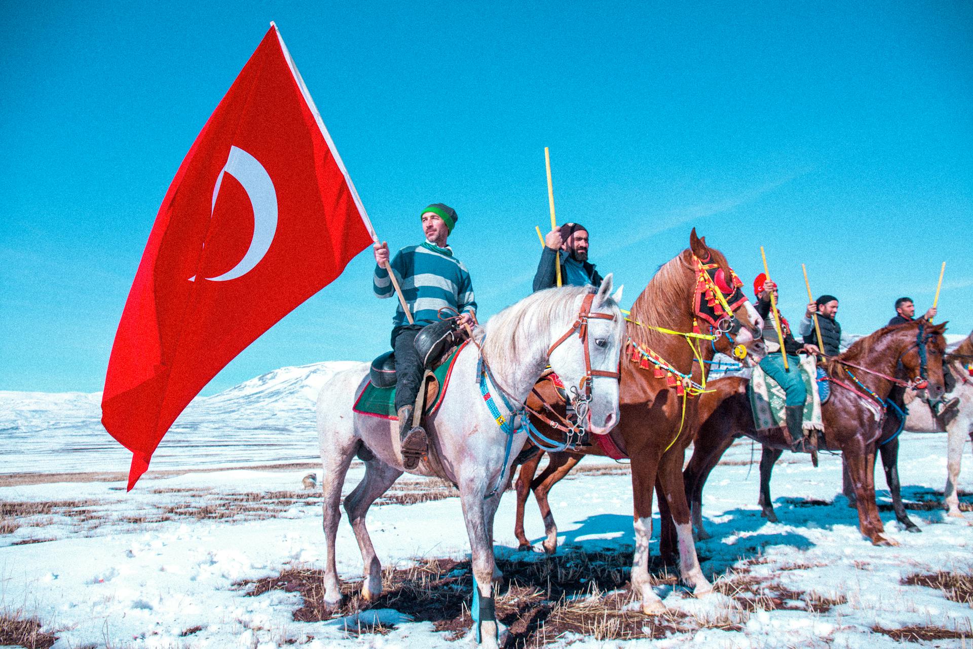 Men Sitting on Horses in Winter with Flag of Turkey