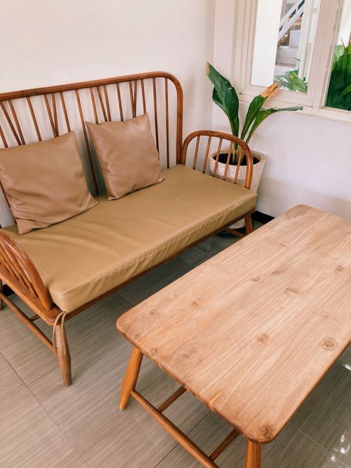 Free Warm and inviting indoor seating with wooden furniture and potted plant. Stock Photo