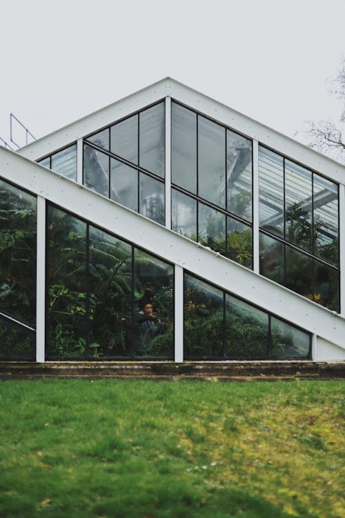 A glass house with a green roof and grass