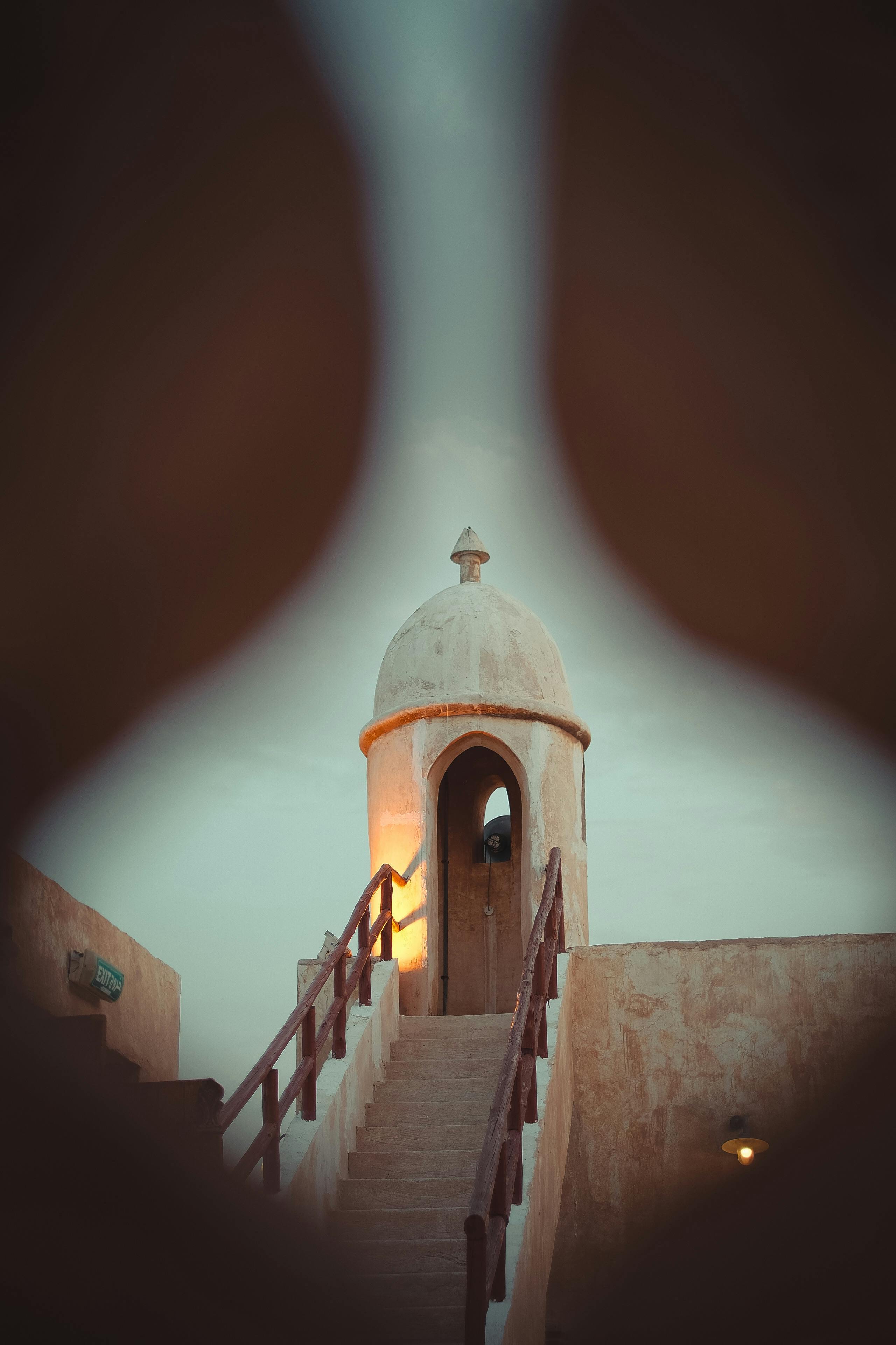 Atmospheric view of a vintage tower with stairs viewed through a peephole.
