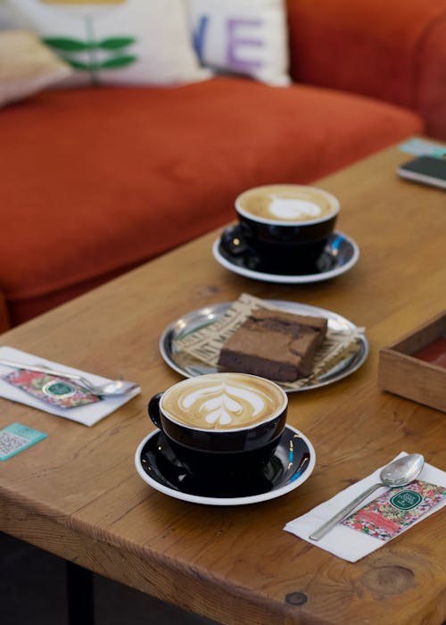 Cups of Cappuccino and Brownie on Table