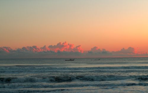 Free Scenic sunset view of Guaratuba Beach with boats on the horizon, capturing tranquil ocean waves. Stock Photo