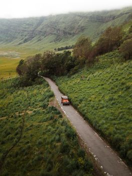 Drone capture of a 4x4 driving through a green valley in East Java, Indonesia.
