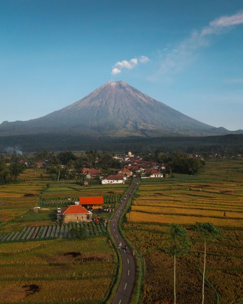 Free Stunning aerial view of rural East Java with a volcano in the backdrop, capturing the essence of Indonesian landscape. Stock Photo