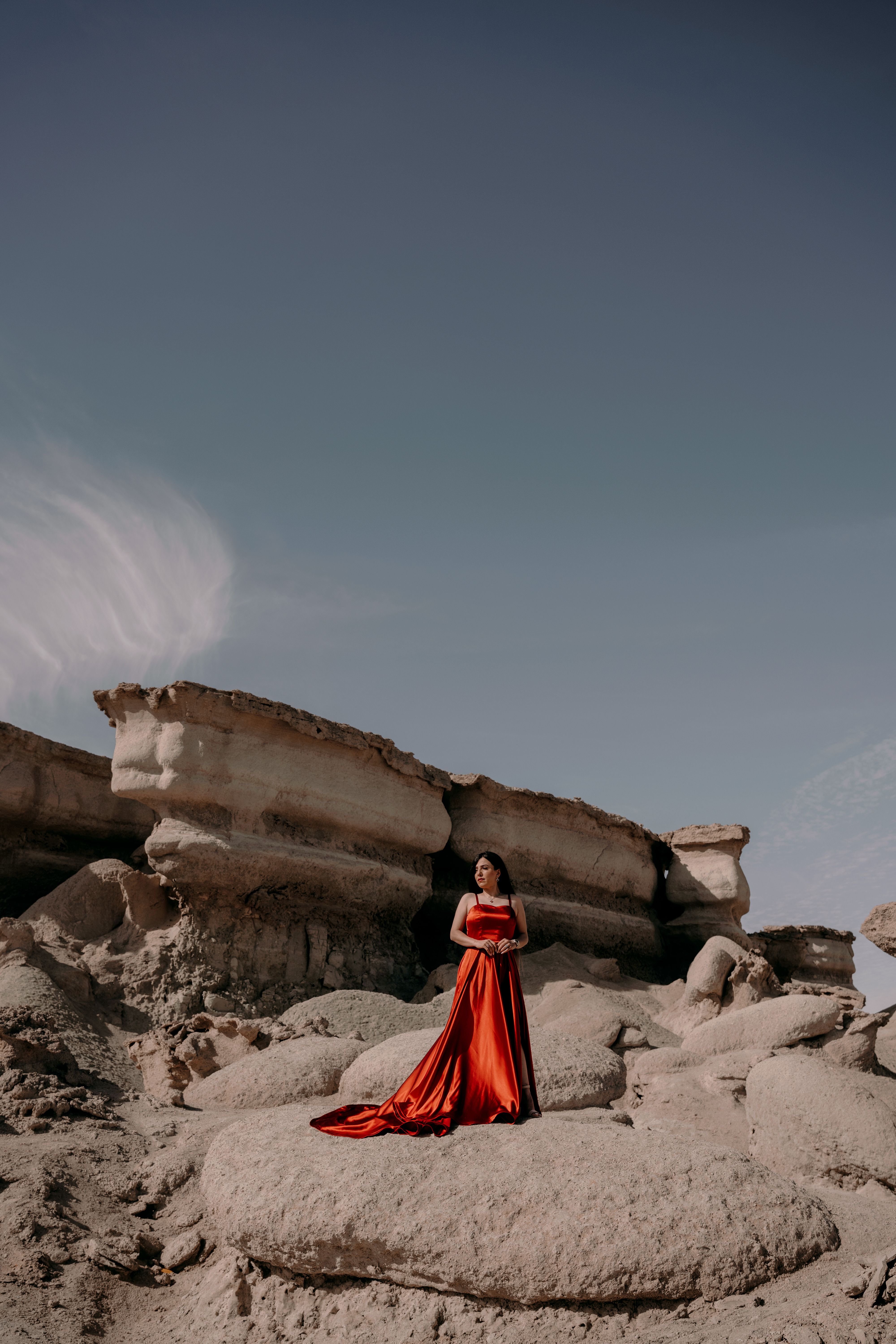Woman in Red Dress Standing on Barren Rocks · Free Stock Photo