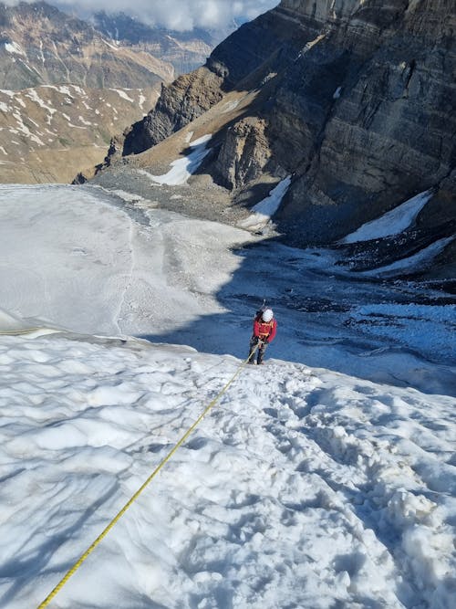 Person Climbing Mountains in Snow