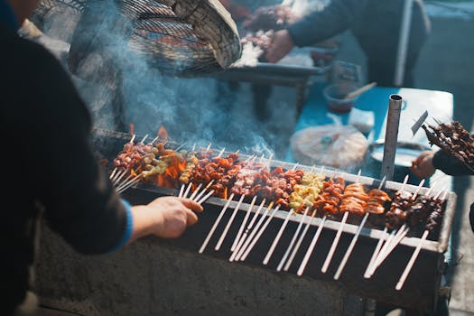 Street vendor grilling assorted meat skewers at an outdoor market stall.