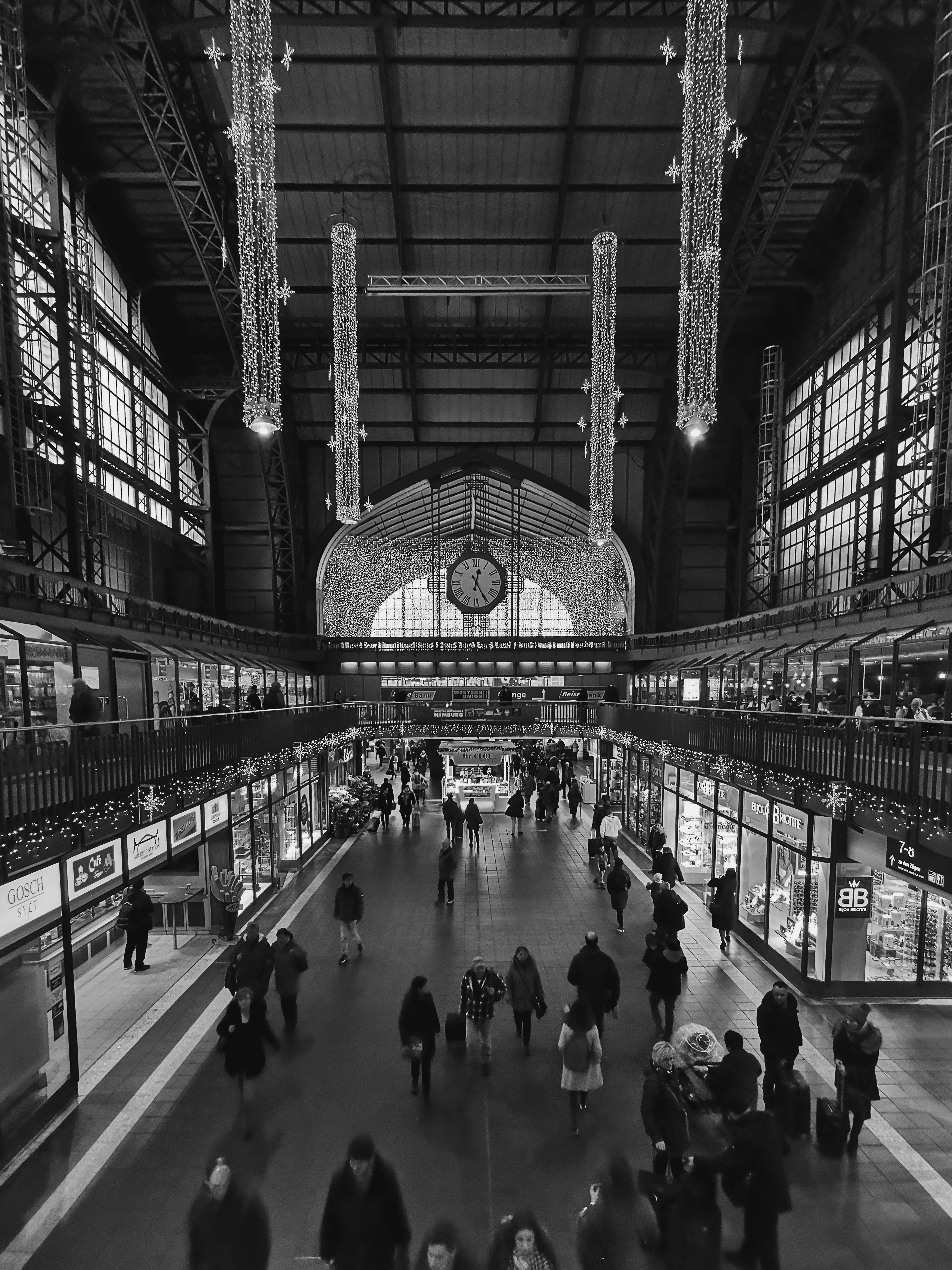 Monochrome view of Hamburg's main station bustling with people and decor.