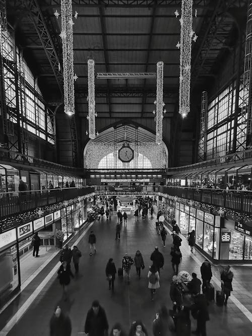 A black and white photo of people in a train station