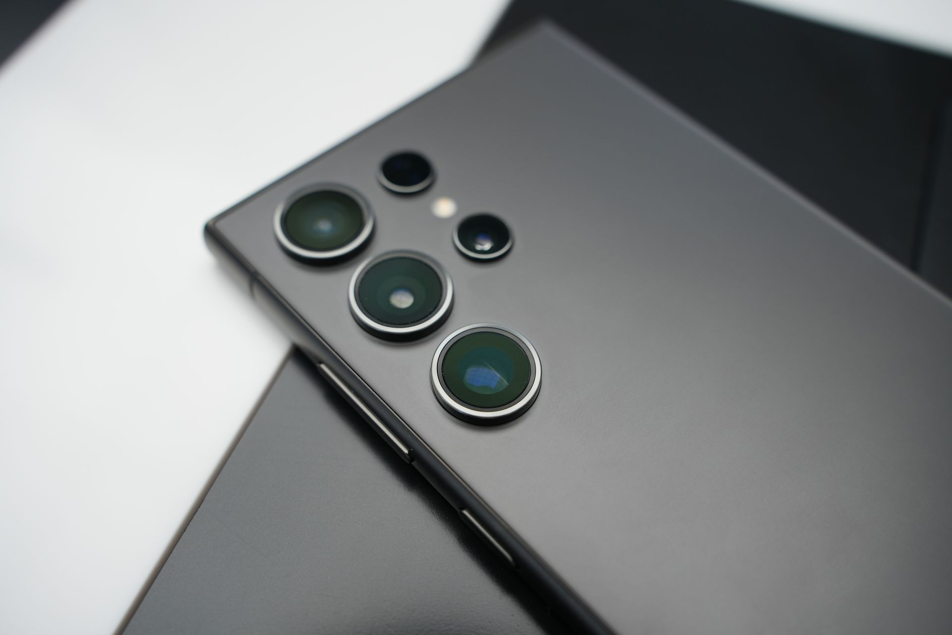 Detailed close-up shot of a smartphone showcasing advanced camera lenses, emphasizing modern technology.