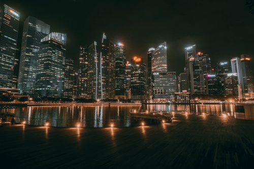 Free A breathtaking view of Marina Bay's modern skyline reflecting on the water at night in Singapore. Stock Photo