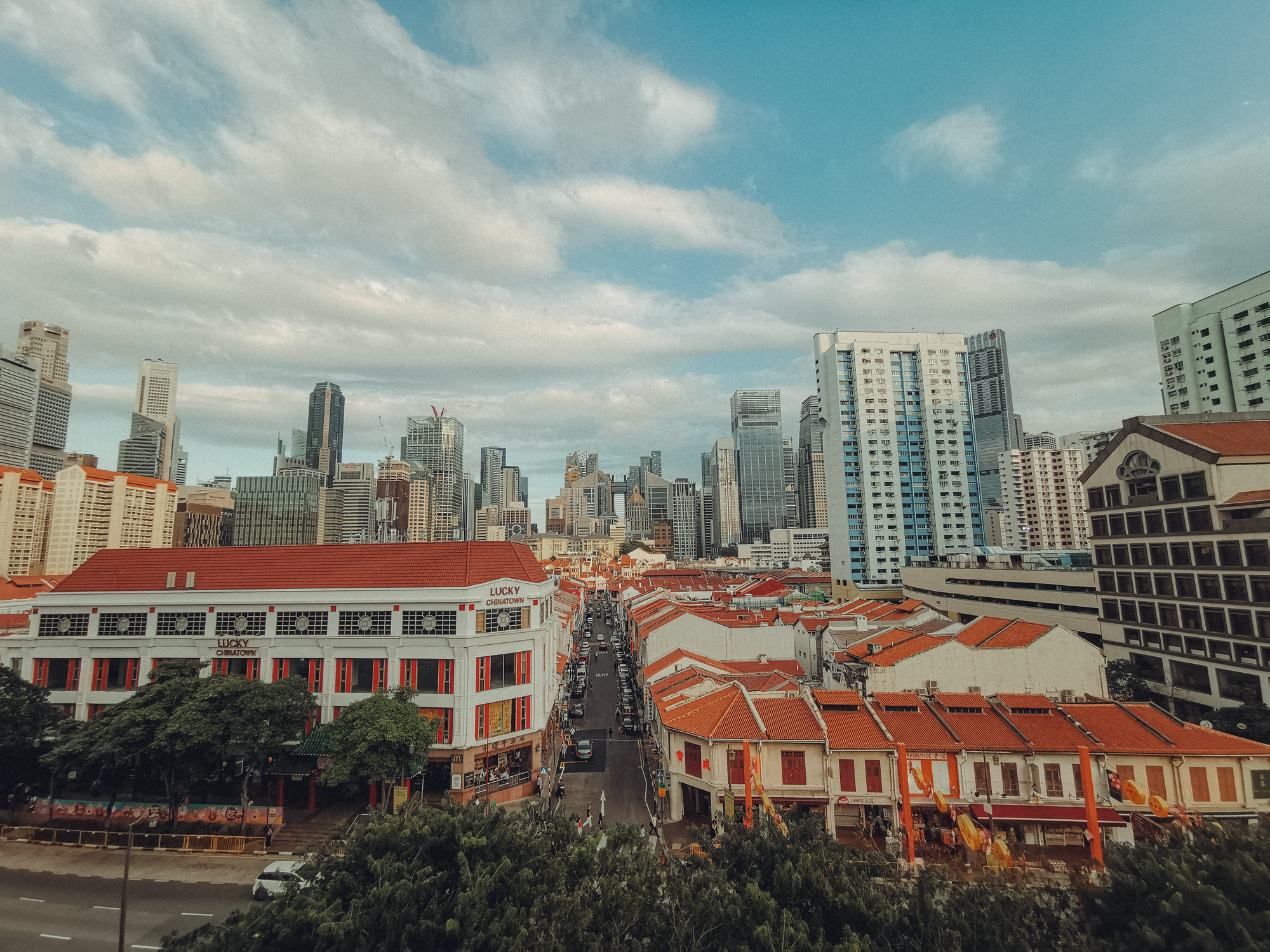 Explore the vibrant contrast of Singapore's Chinatown with modern skyscrapers in the distance