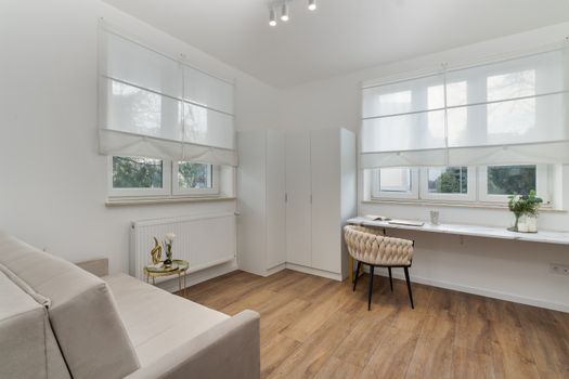 Bright and airy room with modern minimalist decor featuring wooden floors and ample natural light.
