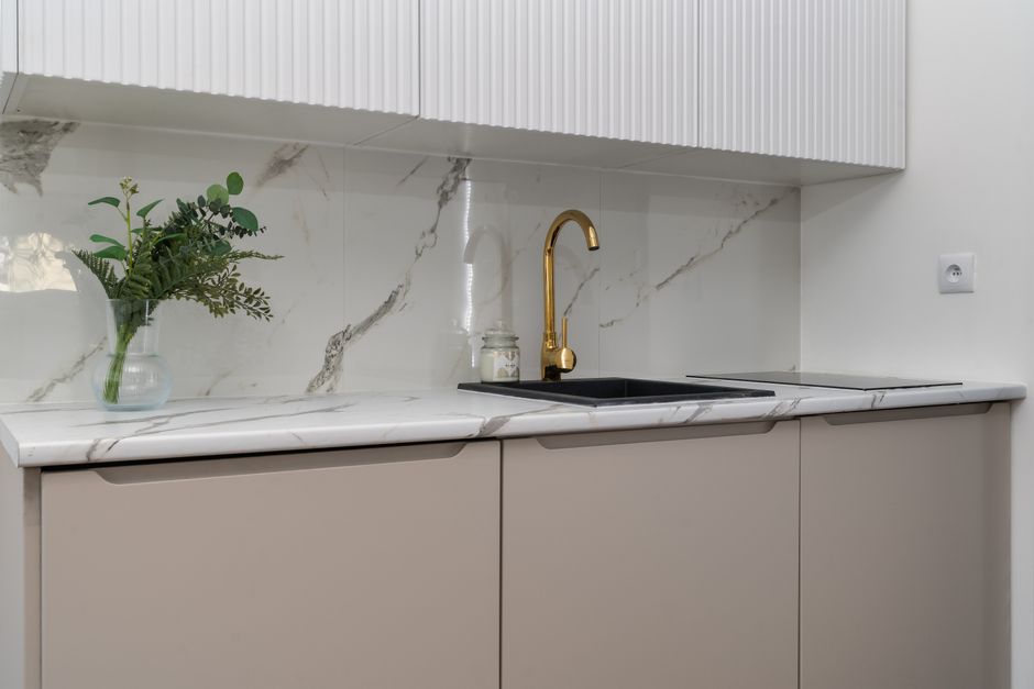 Moderne kleine Küche mit heller Laminat Arbeitsplatte, weißen Fronten und sauberem Zuschnitt als Beispiel für Küchenarbeitsplatte austauschen.