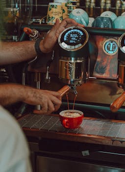 Close-up of barista making coffee with espresso machine in a café.