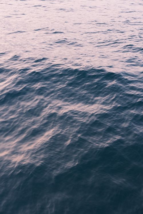 Free A tranquil view of ocean waves under a gentle sunset light, creating a peaceful ambiance. Stock Photo