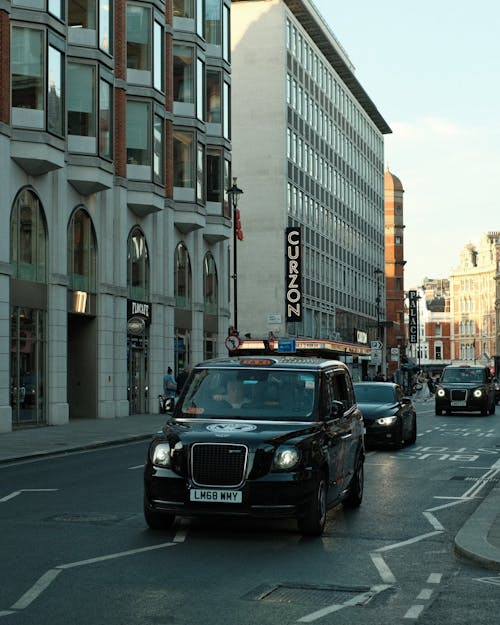 A taxi cab is driving down a city street