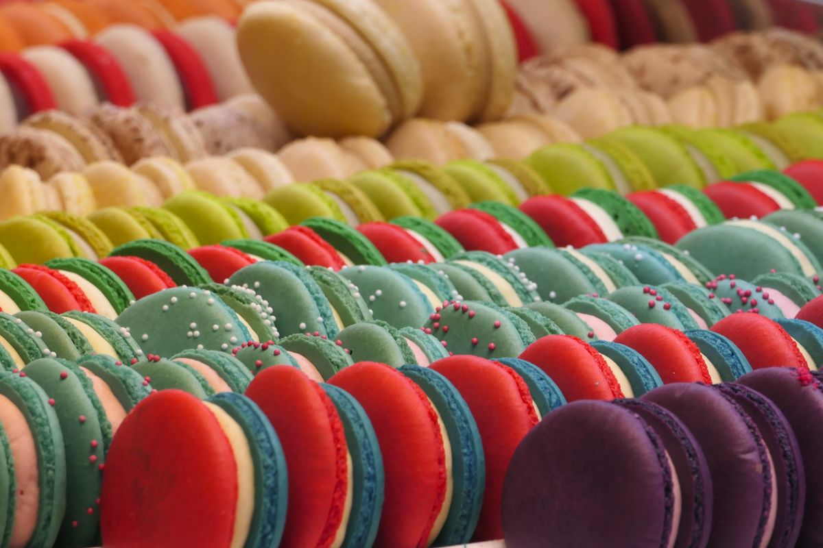 A vibrant selection of colorful macarons arranged in rows showcasing variety and sweetness.