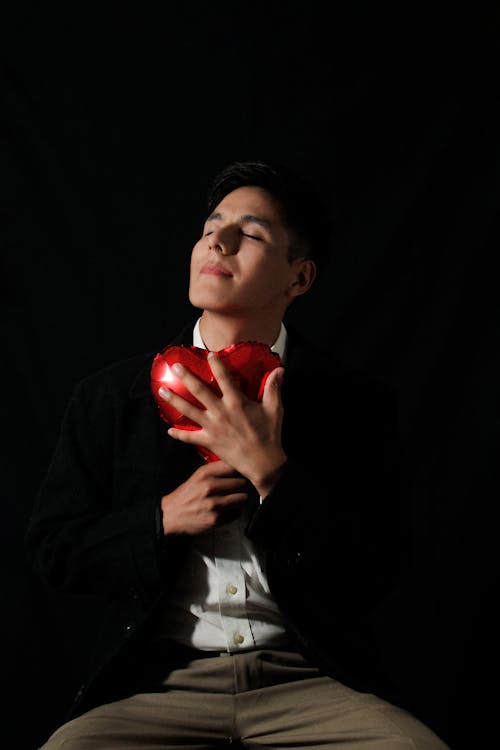 A man holding a red heart in his hands
