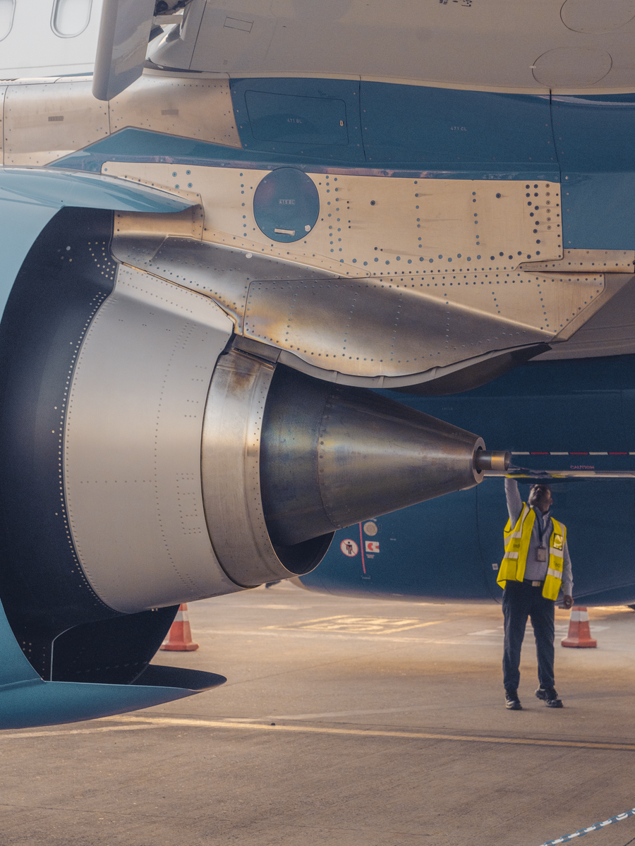 Aviation safety officer inspecting an aircraft engine at airport terminal