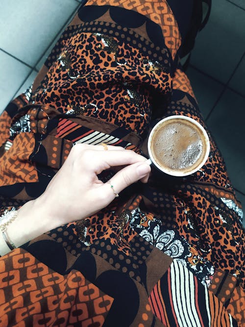A person holding a cup of coffee in their hand