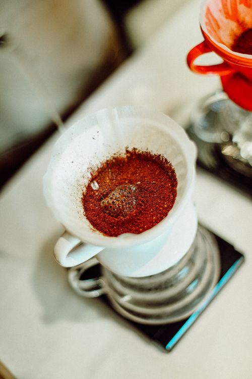 Free A close-up of coffee grounds and water in a white filter, captured from above. Stock Photo